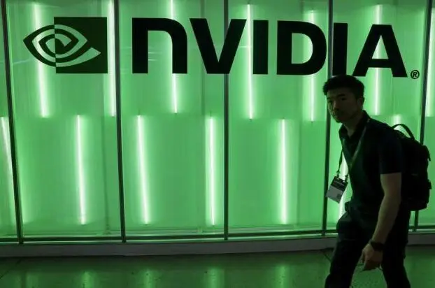 Nvidia logo illuminated in green light with person walking past