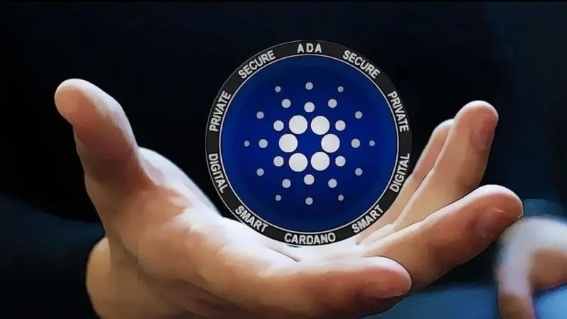 Hand holding Cardano ADA coin showing cryptocurrency logo